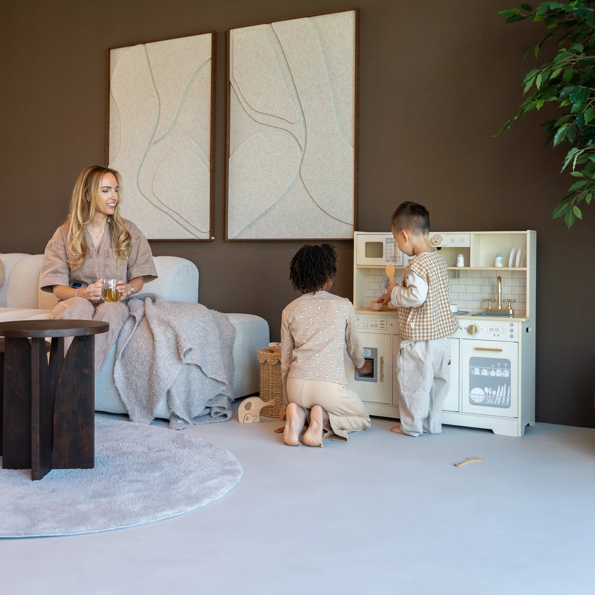 Moeder kijkt toe terwijl twee kinderen spelen met de Baby Doo Luxe houten speelgoedkeuken